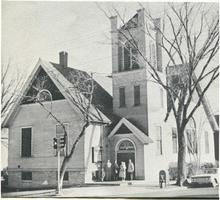 Photograph of a church with a corner tower over a covered entry porch.